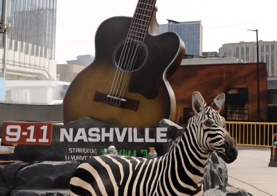 Ed the Zebra posing in front of a guitar in Nashville